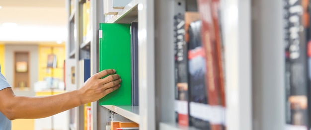 Chiudere la mano scegliendo un libro dallo scaffale.