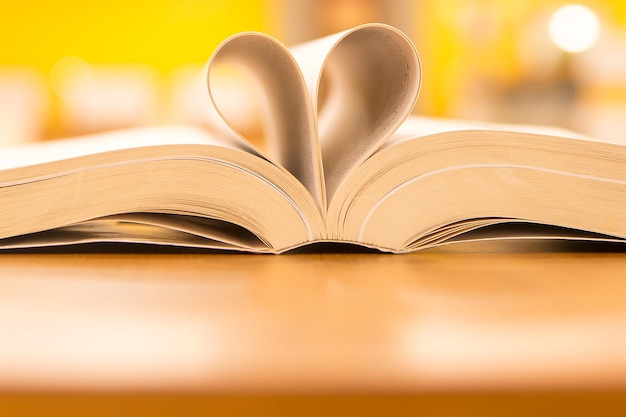 Chiudere la pagina del libro a forma di cuore in biblioteca