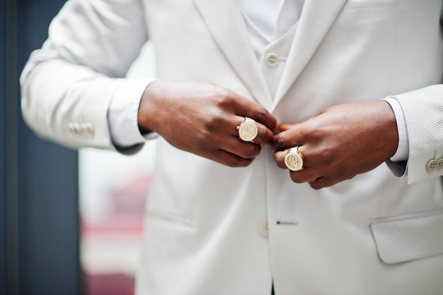 Chiudere le mani con anelli di un bel gentiluomo afroamericano in abbigliamento formale
