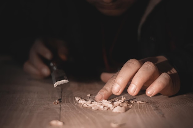 Chiudere le mani del falegname che lavorano con la taglierina