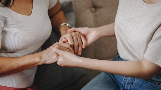 Chiudere le mani della donna anziana e una mano di donna