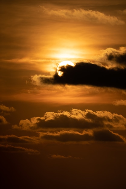 Chiudi il sole con la nuvola davanti al tramonto al tramonto.