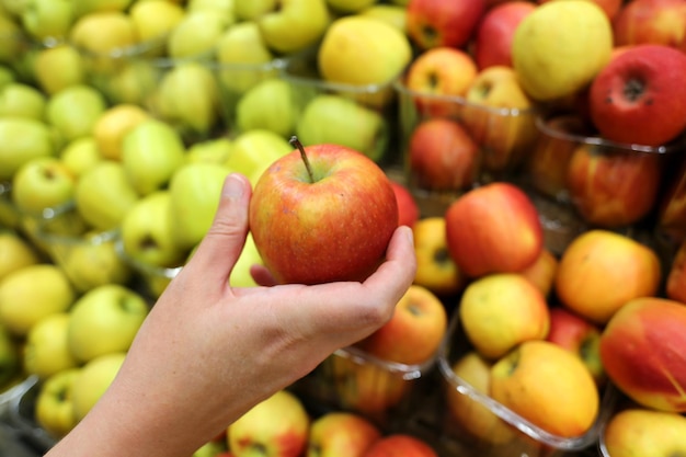 chiusura dei frutti di mele biologiche e rosse selezionati dal cliente nel supermercato