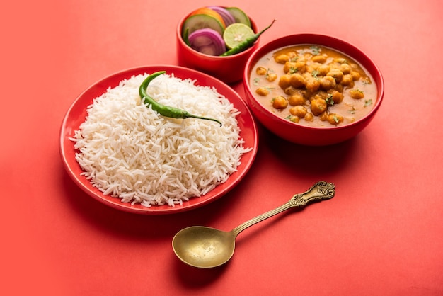 Chole chawal cibo indiano o curry piccante di ceci con riso semplice servito con insalata verde green