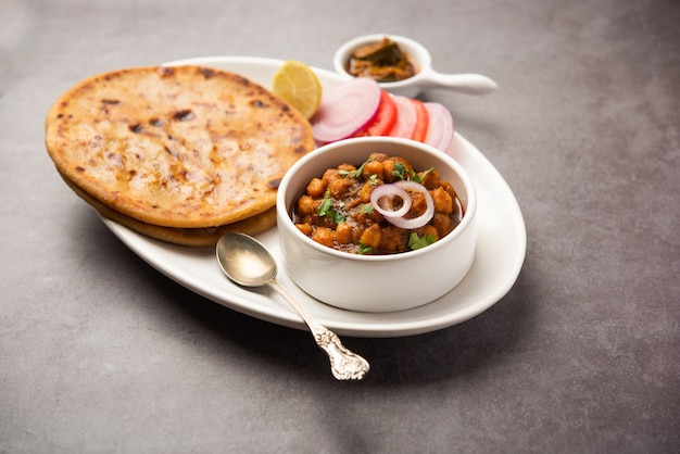 Chole con Aloo Paratha o Alu parantha, popolare ricetta alimentare dell'India settentrionale servita calda con sottaceti di mango