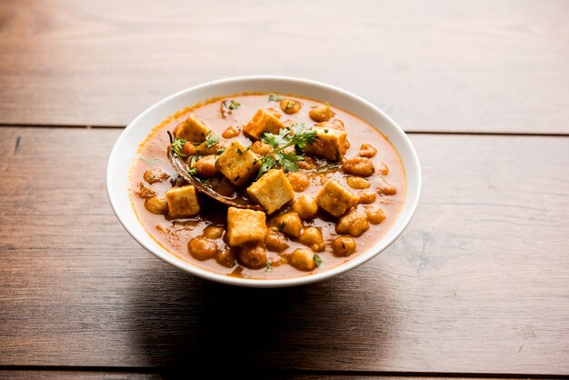 Chole Paneer curry fatto con ceci bolliti con ricotta con spezie. Ricetta popolare dell'India settentrionale. servito in una ciotola o in una teglia. Messa a fuoco selettiva