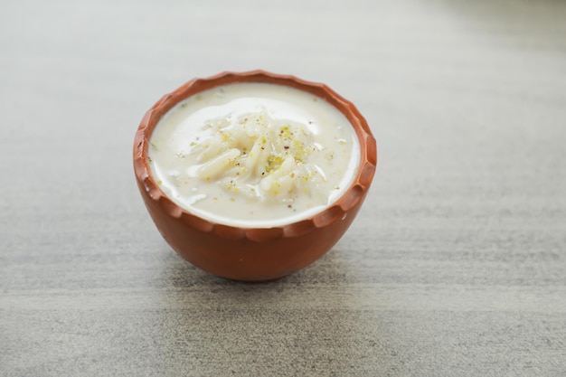 Chui pitha kheer firni servito in vaso isolato su tappetino vista dall'alto di bangali indiano e dolce pakistano mithai