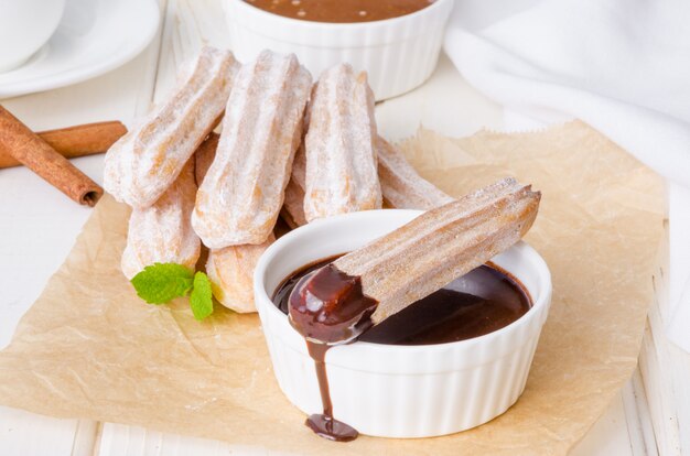 Churros al forno con salsa di cannella, zucchero a velo, cioccolato e caramello.