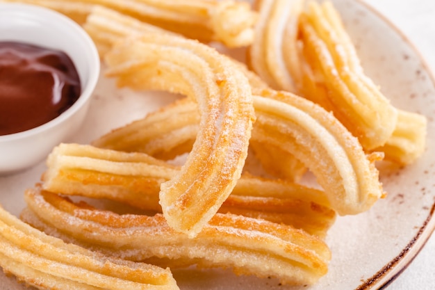 Churros con zucchero a velo e salsa al cioccolato.