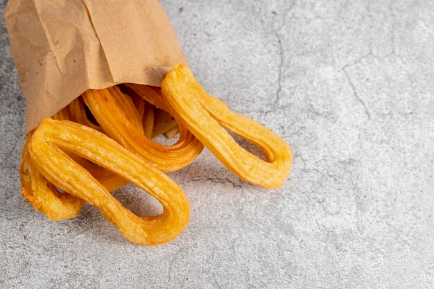 Churros in sacchetto di carta tipica colazione spagnola, su sfondo grigio pietra