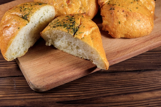 Ciabatta di pane fresco su tagliere su tavola di legno