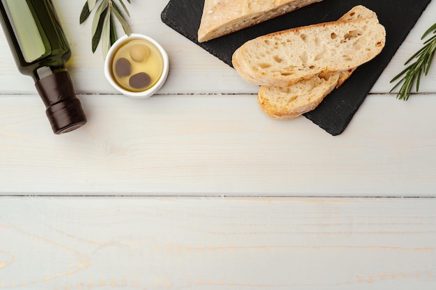 Ciabatta italiana con olio d'oliva su fondo di legno