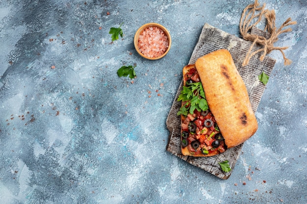 Ciabatta italiana con verdure di pomodoro tritate, erbe aromatiche e olio su baguette croccanti grigliate o tostate. Bruschette all'italiana. banner, menu, posto ricetta per testo, vista dall'alto.