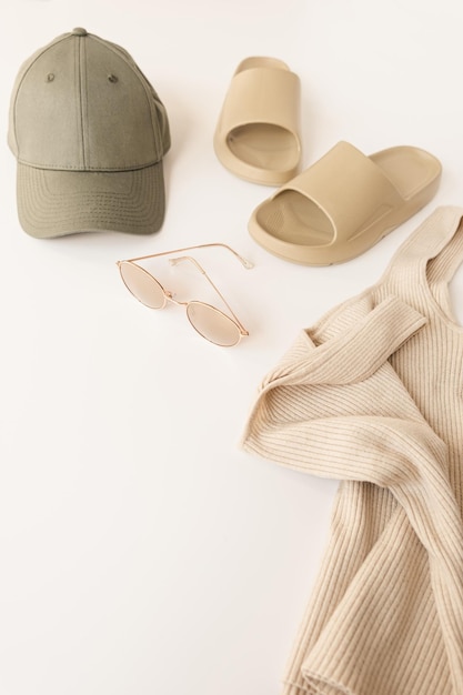 Ciabatte beige con cappuccio per occhiali da sole su tavolo bianco Panno moda femminile e concetto di accessorio Colore neutro e polveroso