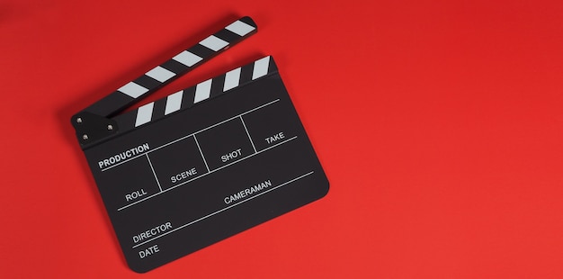 Ciak o ciak o ardesia cinematografica. È utilizzato nella produzione di video, film, industria cinematografica su sfondo rosso.