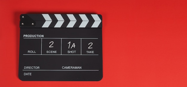Ciak o ciak o ardesia cinematografica. È utilizzato nella produzione di video, film, industria cinematografica su sfondo rosso.
