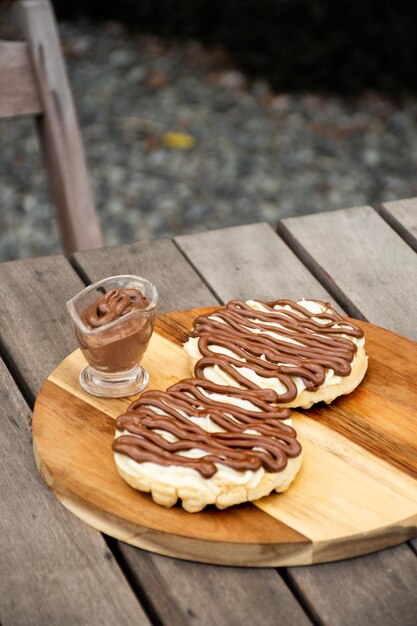 Cialda al cioccolato con nocciola e cioccolato bianco su tavola di legno su tavolo di legno in giardino