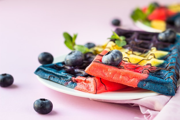 Cialde belghe colorate con glassa al cioccolato, mirtilli e menta