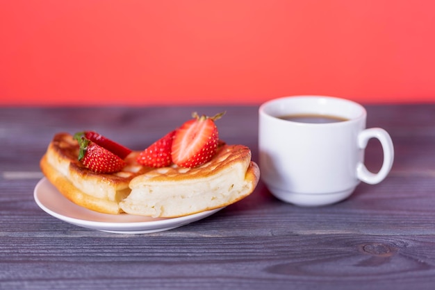 Cialde belghe con fragole e caffè su un tavolo di legno scuro