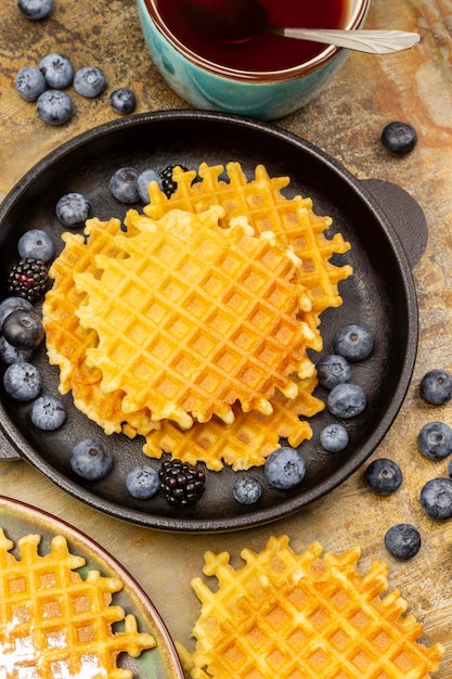 Cialde belghe e mirtilli in padella Cialde e frutti di bosco sul tavolo