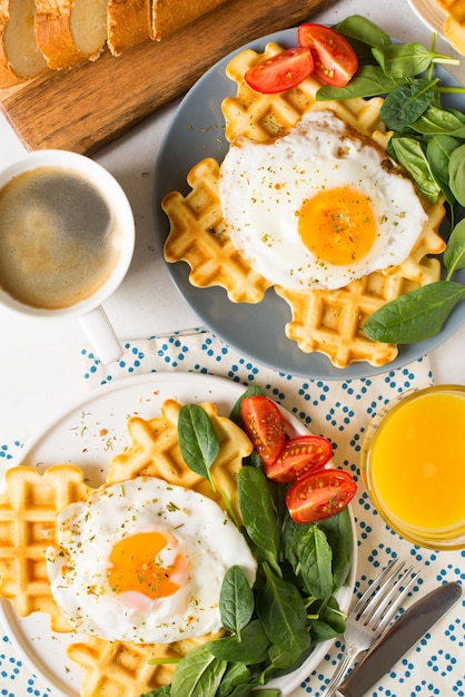 Cialde di spinaci all'uovo fritto e tazza di caffè espresso su sfondo bianco piatto