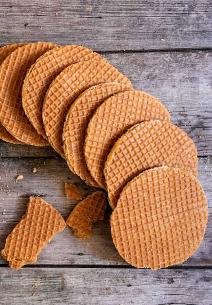 Cialde olandesi tradizionali con caramello sullo sfondo di legno, vista dall'alto.