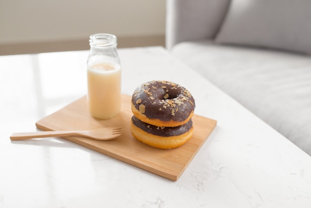 Ciambella al cioccolato. Colazione mattutina con latte sul tavolo nel soggiorno di casa.