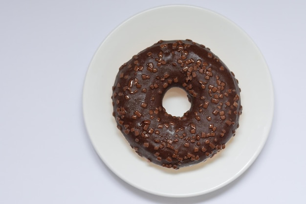 ciambella al cioccolato sul piatto bianco su fondo bianco