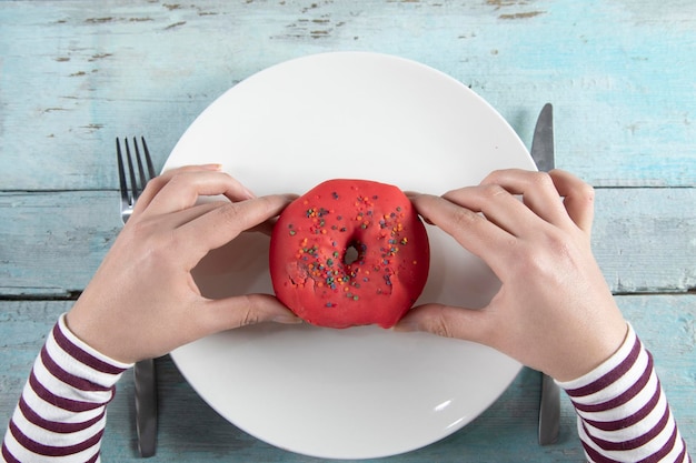 Ciambella della mano della donna nel piatto