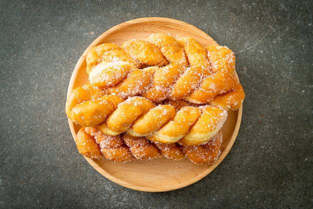 ciambella di zucchero a forma di spirale sul piatto di legno