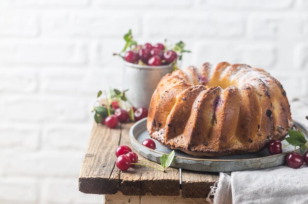 Ciambella fresca fatta in casa con ciliegia su tavola di legno