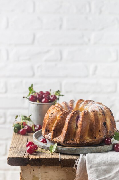 Ciambella fresca fatta in casa con ciliegia su tavola di legno