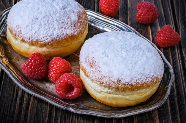 Ciambella ripiena di gelatina berlinese con lampone e ribes su legno