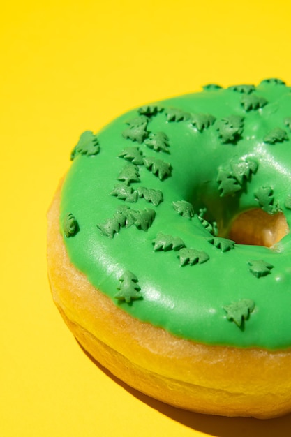 Ciambella verde su sfondo giallo dalla foto verticale laterale Scatto in studio