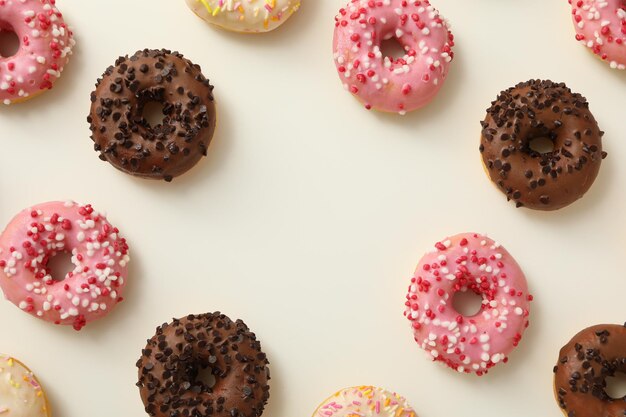 Ciambelle bianche e rosa al cioccolato su sfondo bianco spazio per il testo