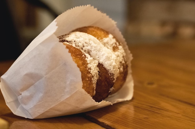 Ciambelle con zucchero a velo su un tavolo di legno