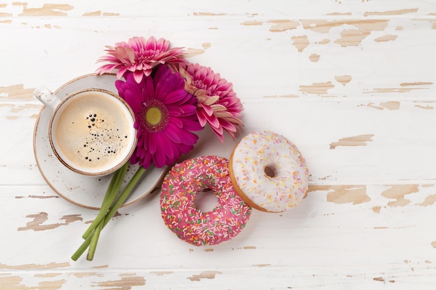 Ciambelle della tazza di caffè e fiori della gerbera