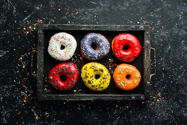 Ciambelle dolci colorate in una scatola di legno Vista dall'alto Flat Lay