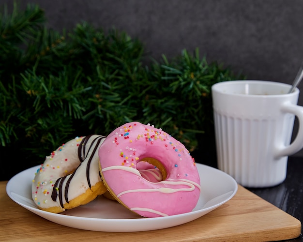 Ciambelle rosa sul piatto con caffè