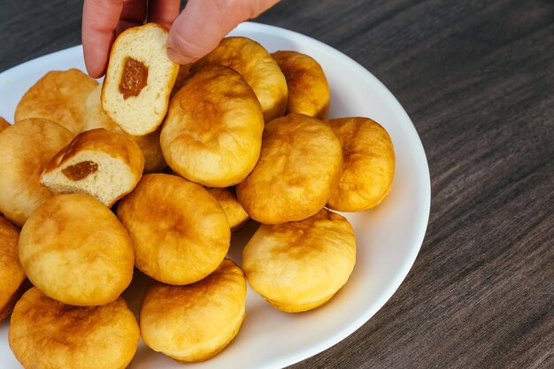 Ciambelle tedesche berliner con marmellata e zucchero a velo in un vassoio su uno sfondo di legno scuro spazio per il testo