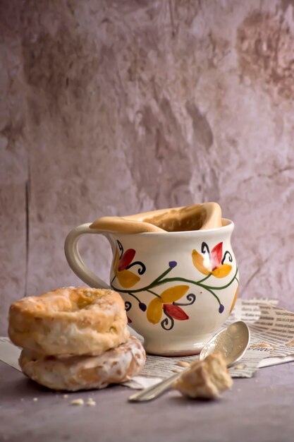 Ciambelle tradizionali accanto a una tazza vintage con latte