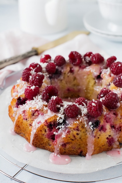 Ciambellone al limone con lamponi su una luce.