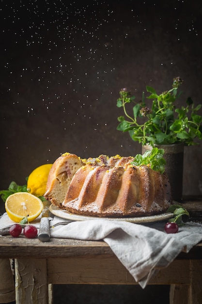 Ciambellone al limone fatto in casa con zucchero a velo su fondo nero