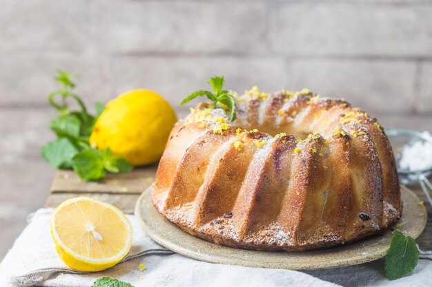 Ciambellone al limone fatto in casa con zucchero a velo su fondo nero