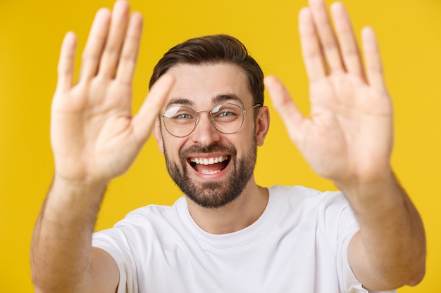 Ciao. Ritratto di felice amichevole uomo dai capelli castani con barba piccola in camicia bianca