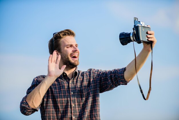 Ciao sono qui viaggio con la macchina fotografica stile di moda maschile alla moda uomo macho alla moda con la macchina fotografica uomo sexy reporter turistico cattura fotografo di avventura giornalista con gli occhiali fai selfie