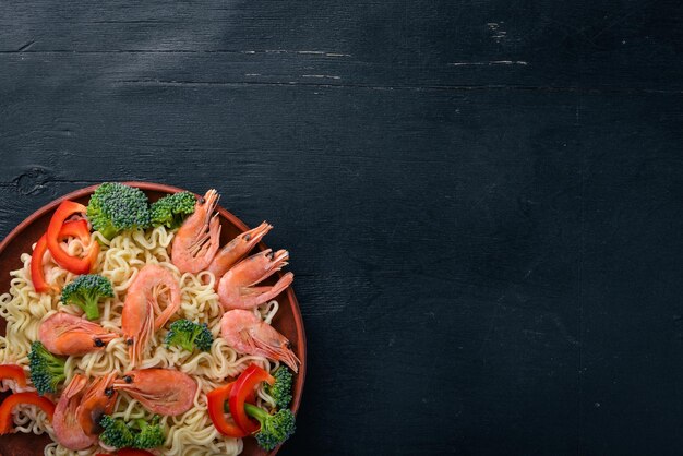 Cibo asiatico con frutti di mare e verdure Gamberetti broccoli paprika spezie Vista dall'alto Spazio libero per il testo