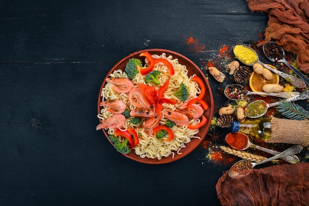 Cibo asiatico con frutti di mare e verdure Gamberetti broccoli paprika spezie Vista dall'alto Spazio libero per il testo