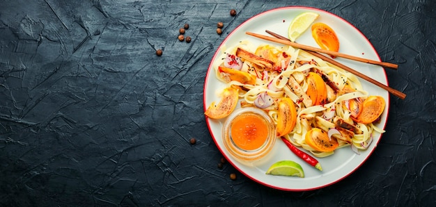 Cibo asiatico, insalata con pasta, cachi e melanzane.