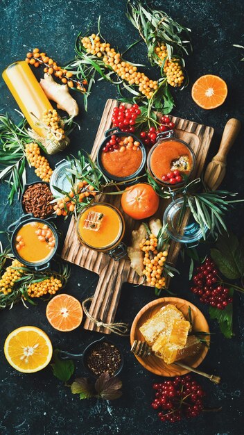 Cibo autunnale concetto frutti di bosco miele agrumi Alimenti con un alto contenuto di vitamina C Su uno sfondo scuro vista dall'alto